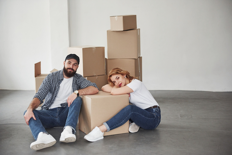 Ett par som sitter intill flyttkartonger